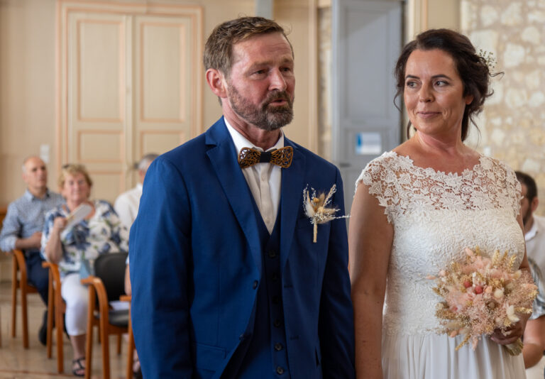 Les mariés à la mairie lui en costume bleu et elle en robe de mariée photographe mariage gers