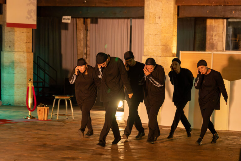 photos de théâtre un groupe habillé de noir avec des téléphones à l'oreille.