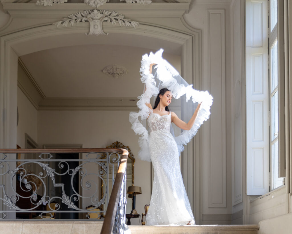 Lola joue avec son voile de mariée sur le pallier du château de la Baronnie