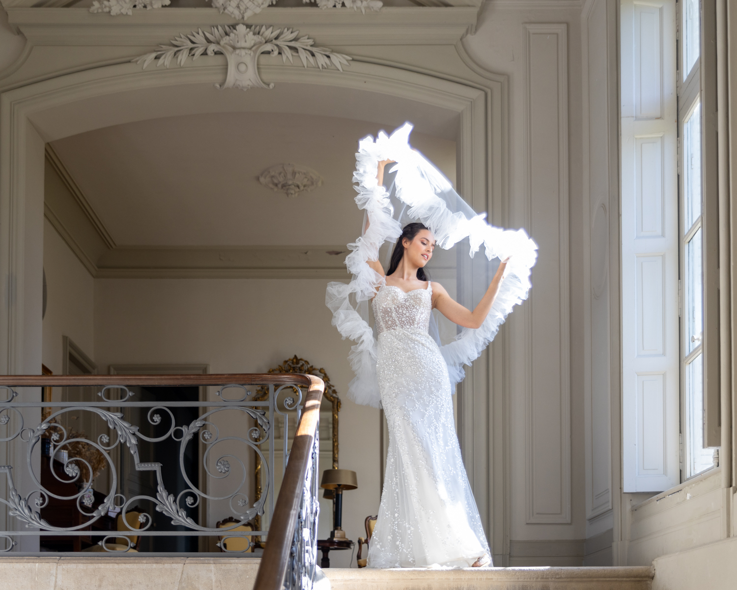 Lola joue avec son voile de mariée sur le pallier du château de la Baronnie