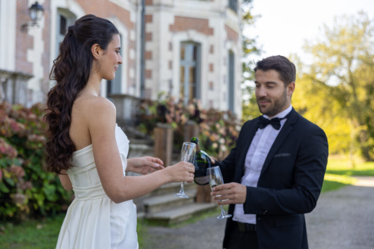 Mariage Lola et Gabriel Château de la baronnie Gabriel sert une coupe de champagne à Lola
