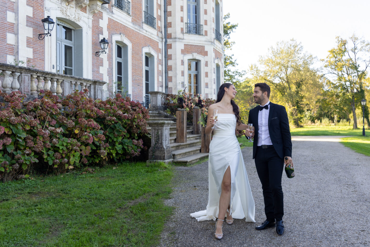 Mariage Lola et Gabriel Château de la baronnie, Lola et Gabriel sont devant le château et trinquent autour d'une coupe de champagne, ils se regardent amoureusement