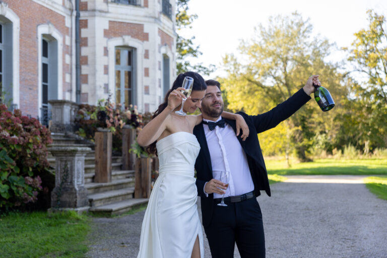 Mariage Lola et Gabriel Château de la baronnie, Lola et Gabriel sont devant le château et trinquent autour d'une coupe de champagne