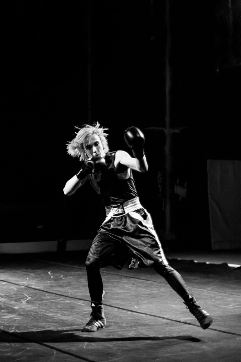 Jeune artiste du Pop Circus en tenue de boxeur effectuant une figure acrobatique sur scène lors du cabaret AAA à Auch.