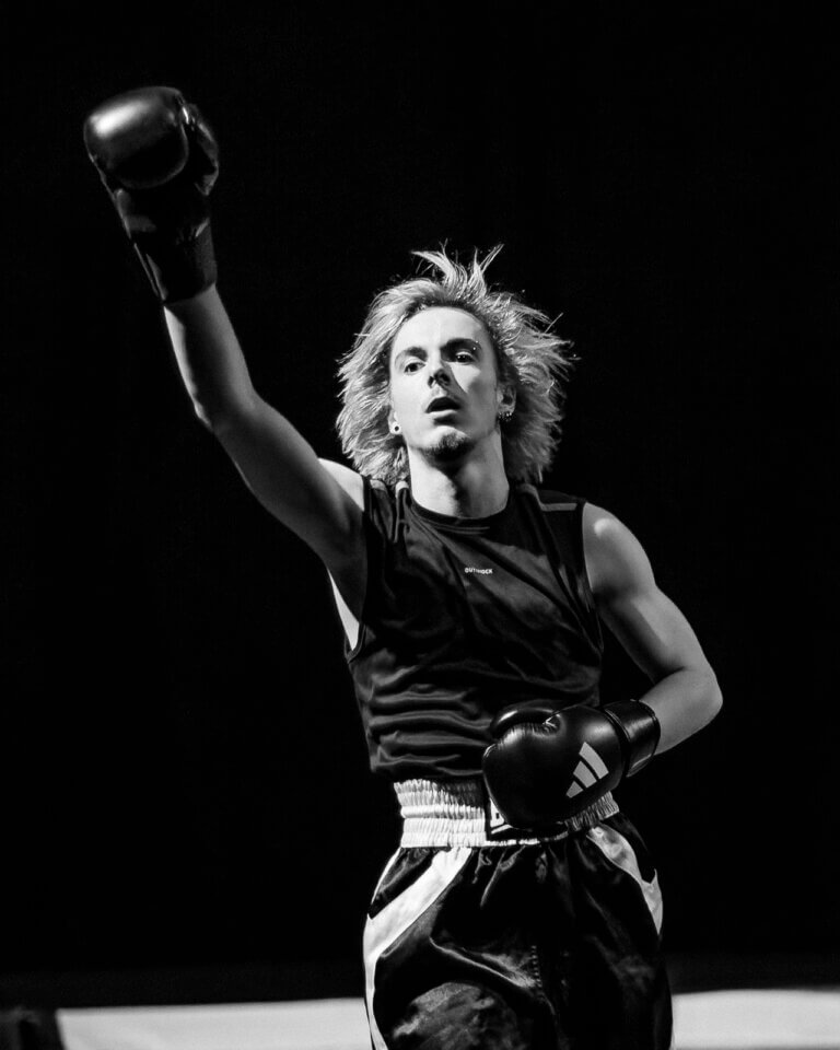 Jeune artiste du Pop Circus en tenue de boxeur effectuant une figure acrobatique sur scène lors du cabaret AAA à Auch.