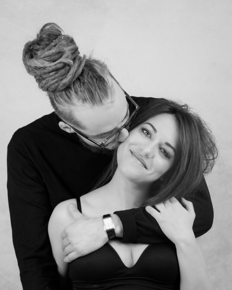 Portrait noir et blanc d'une femme enceinte de profil en studio, main posée sur son ventre