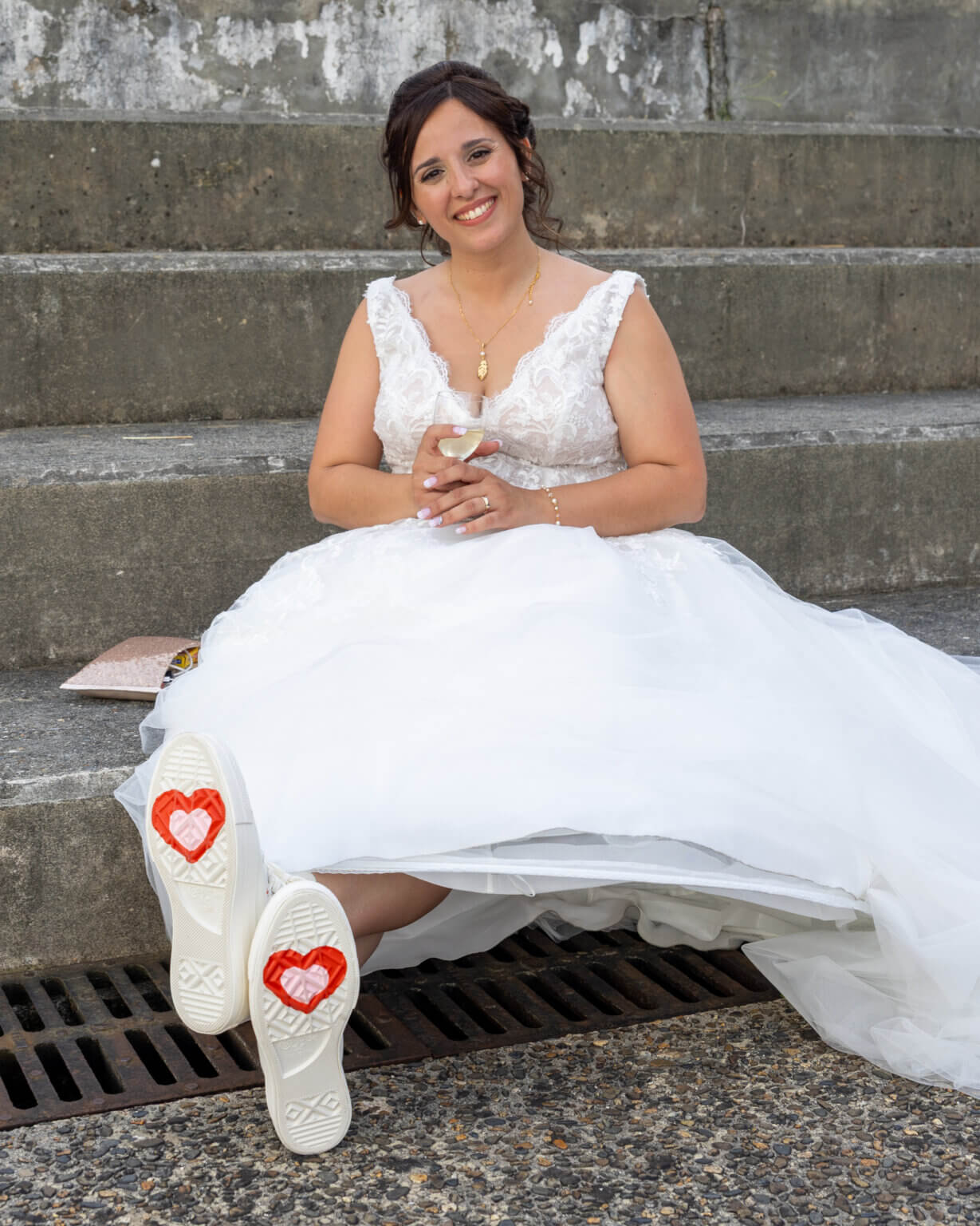 Mariée en train de changer ses chaussures pour des Converse blanches lors du mariage dans les Landes