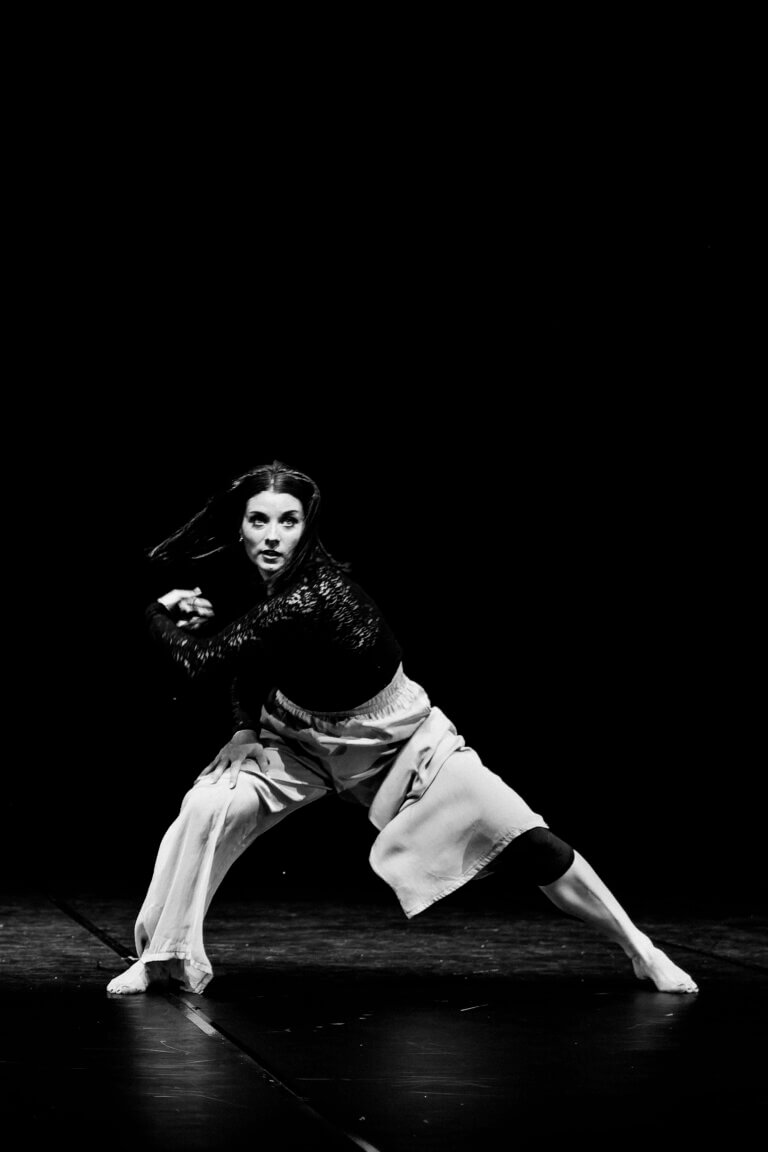 Danseuse seule sur scène, expression intense, éclairage en clair-obscur