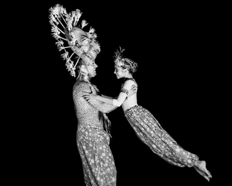 Deux danseurs adultes sur scène, incarnant Mufasa et Simba adolescent, en mouvement synchronisé
