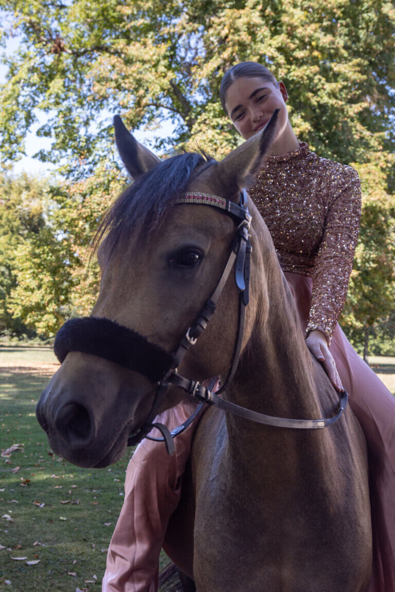 Portrait en extérieur de Naïs avec sa ponette Javana, un moment de tendresse et de connexion dans la nature