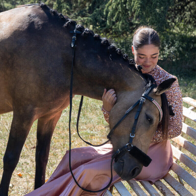 Portrait en extérieur de Naïs avec sa ponette Javana, un moment de tendresse et de connexion dans la nature