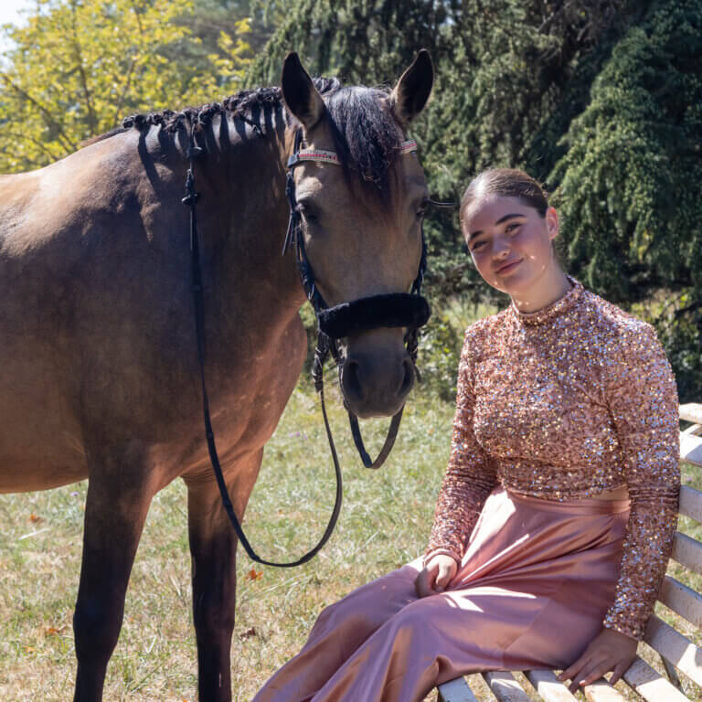 Portrait en extérieur de Naïs avec sa ponette Javana, un moment de tendresse et de connexion dans la nature