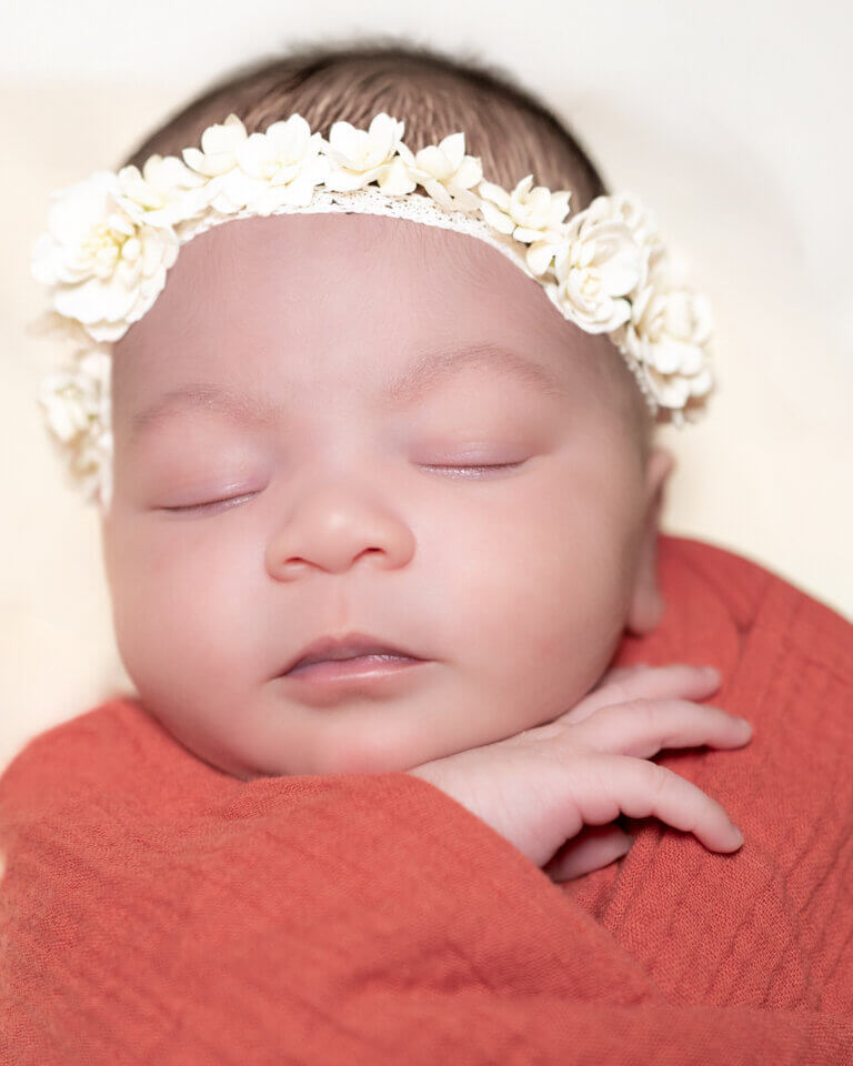 nouveau-né emmailloté dans des tissus terracotta – séance photo naissance à Auch par Laure Geoffroy Photographie bébé endormi entouré de couleurs chaudes terracotta en studio photo à Auch portrait de nouveau-né dans des tons naturels et terre cuite – Laure Geoffroy Photographie Gers
