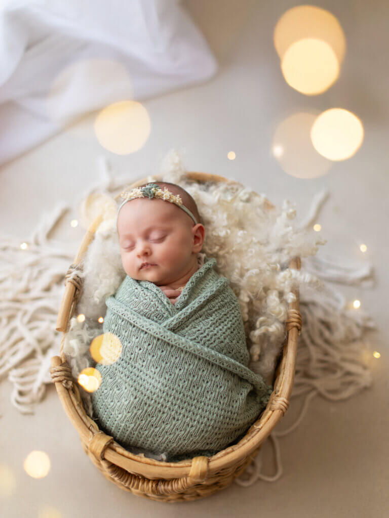 nouveau-né endormi photographié en studio par Laure Geoffroy Photographie bébé emmailloté sur couverture douce – séance photo naissance dans le Gers à Auch portrait de nouveau-né avec accessoires naturels et lumière douce