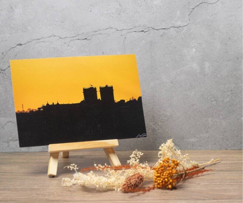 Carte postale représentant la silhouette de la cathédrale Sainte-Marie d'Auch au coucher du soleil sur un ciel orange intense.