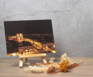 Carte postale représentant une vue panoramique nocturne d'Auch avec la cathédrale Sainte-Marie illuminée au cœur de la ville.