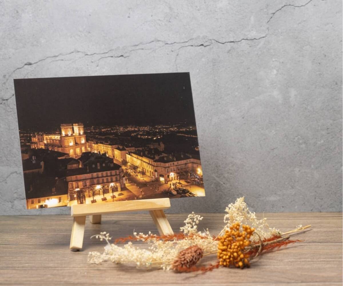 Carte postale représentant une vue panoramique nocturne d'Auch avec la cathédrale Sainte-Marie illuminée au cœur de la ville.