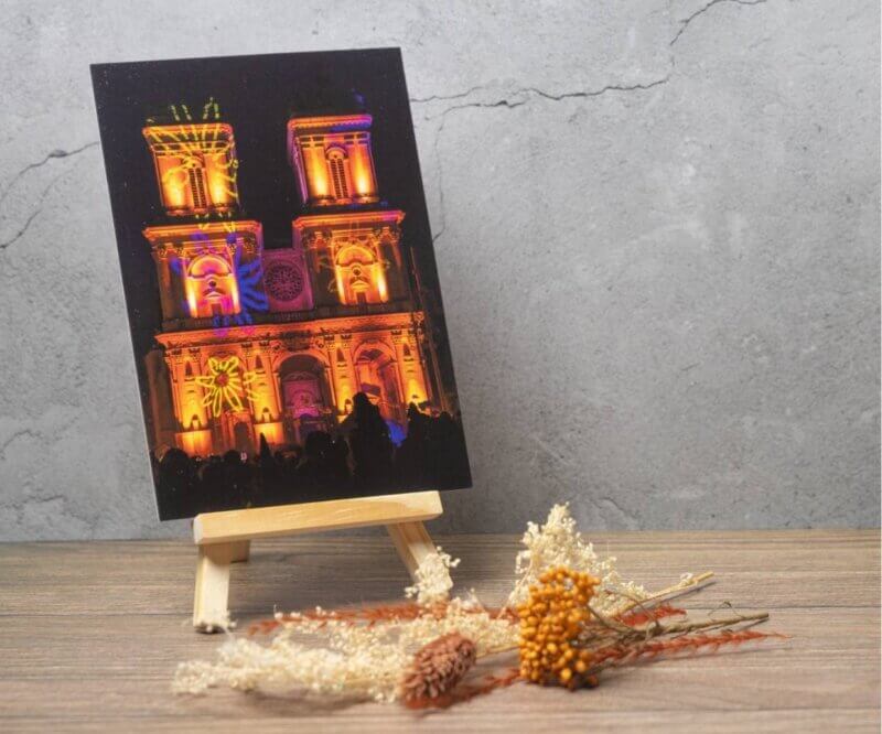 Carte postale représentant la cathédrale Sainte-Marie d'Auch illuminée lors d'un spectacle de lumière nocturne dans le Gers.