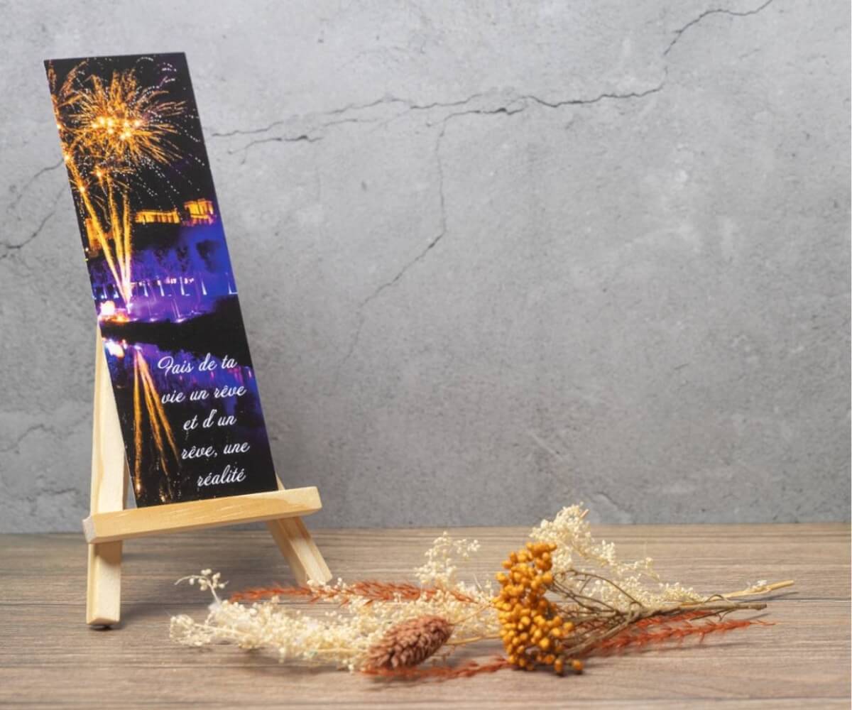 Marque-page illustré par un feu d'artifice au-dessus d'un plan d'eau avec la citation « Fais de ta vie un rêve et d'un rêve une réalité ».
