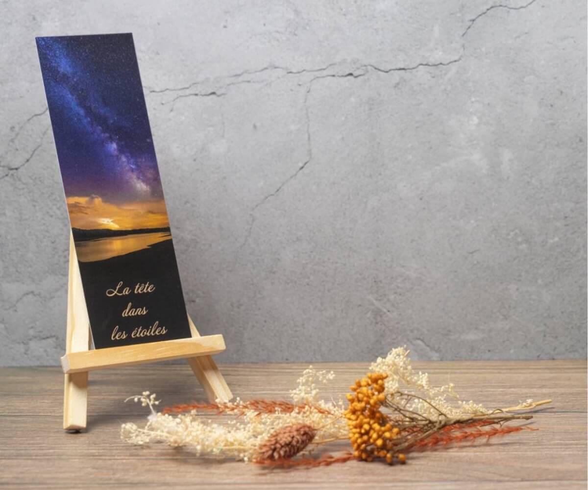 Marque-page illustré par la Voie lactée au-dessus d'un lac avec la citation « La tête dans les étoiles ».