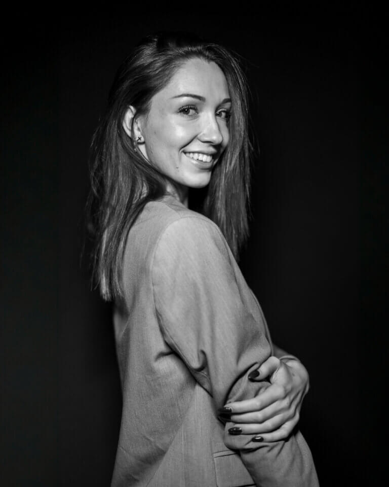 Portrait noir et blanc d’Ana en studio avec un blazer gris pour un book photo professionnel