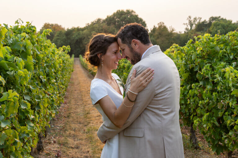 Couple de mariés front contre front dans les vignes au coucher de soleil dans le Gers