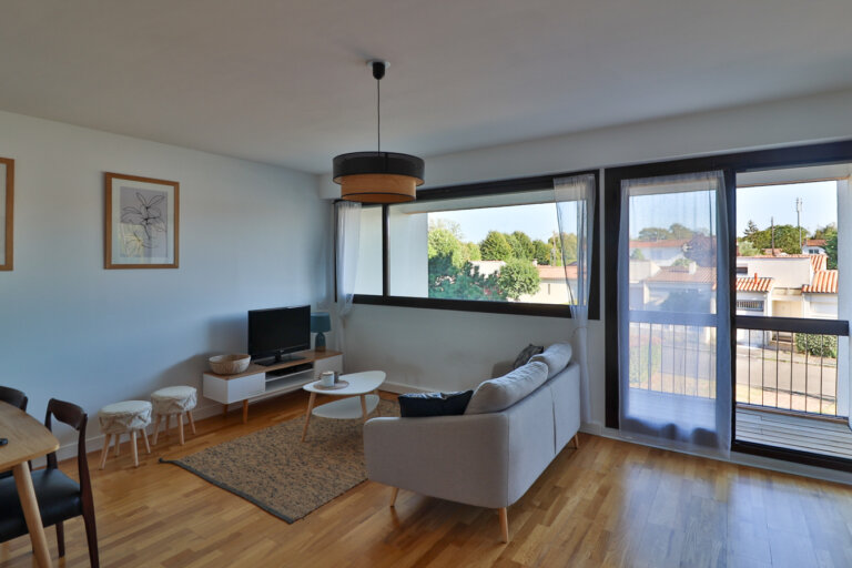 Salon lumineux avec balcon dans un appartement Airbnb à La Rochelle