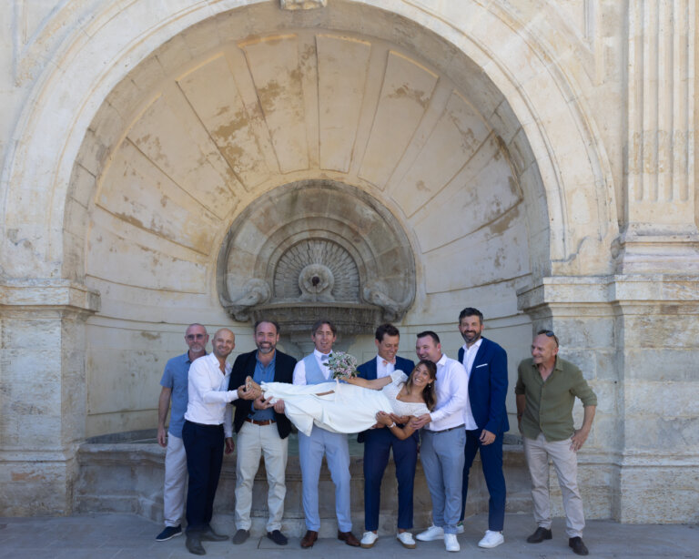 Photo de groupe des hommes portant la mariée devant la fontaine de l’Escalier Monumental d’Auch