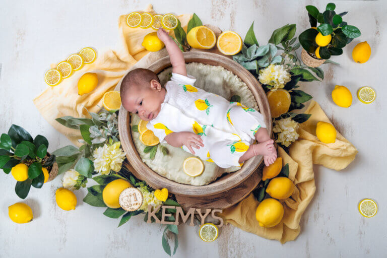 Bébé d’un mois photographié dans un décor jaune et vert sur le thème du citron.