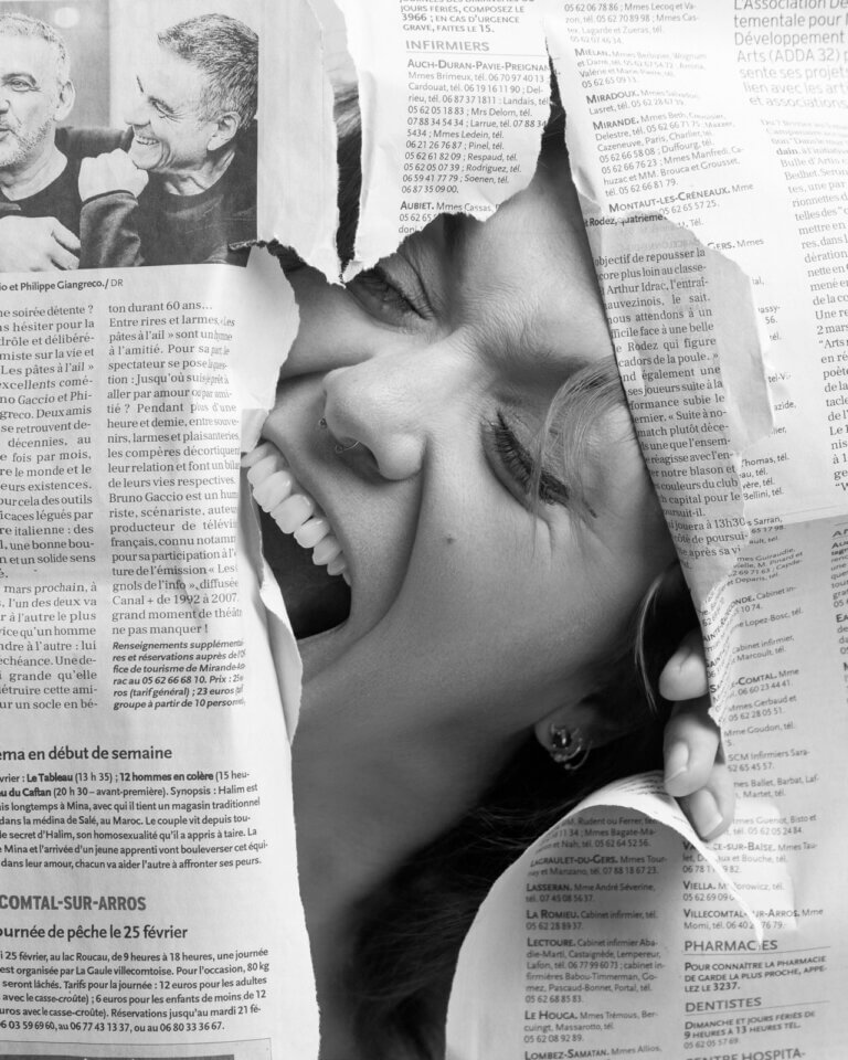 Portrait en noir et blanc d’une femme souriante apparaissant à travers une ouverture dans un journal déchiré.